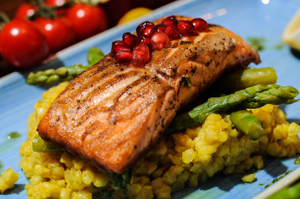 Pan fried salmon fillet served with asparaagus barley, pomerganate and olive oil